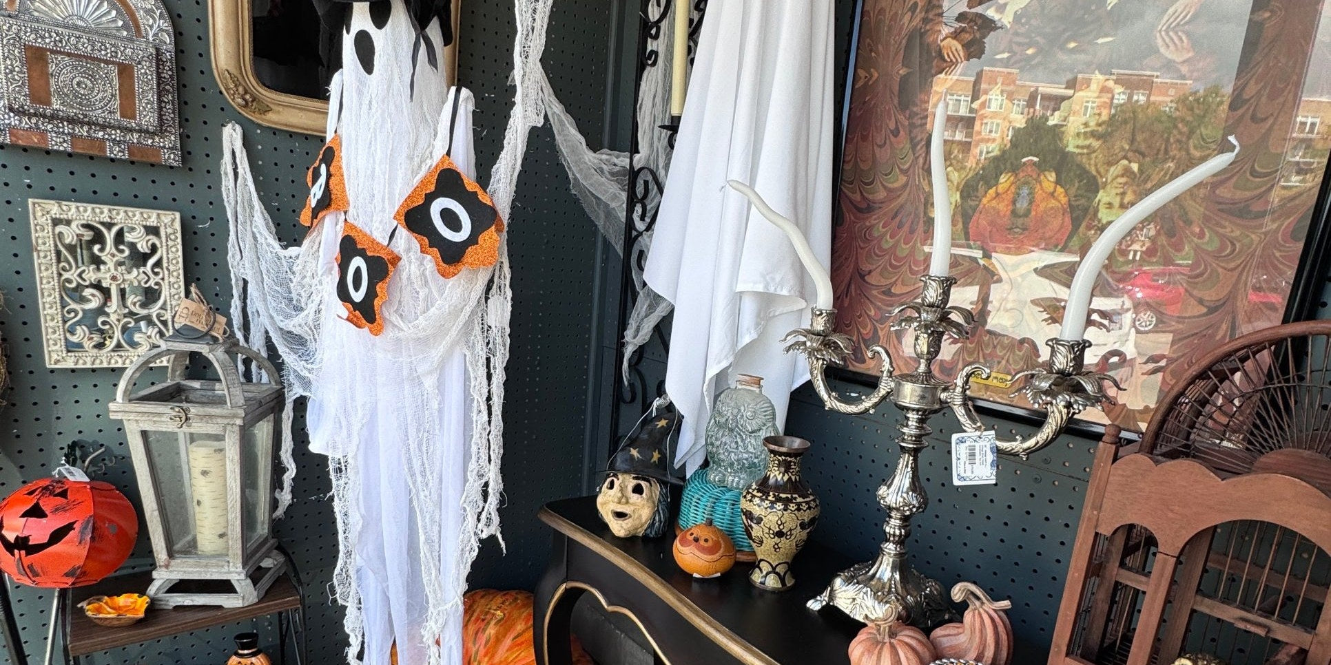 Halloween vignette in a dealer booth at Jackson Square Collective, with two white ghosts, a BOO banner, a silver candelabra, a vintage witch figure, owl figurines, pumpkins and a chevron crochet afghan | Jackson Square Collective in La Grange Park, IL