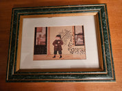 Framed Print of Boy Carrying a Tree as Snow Falls
