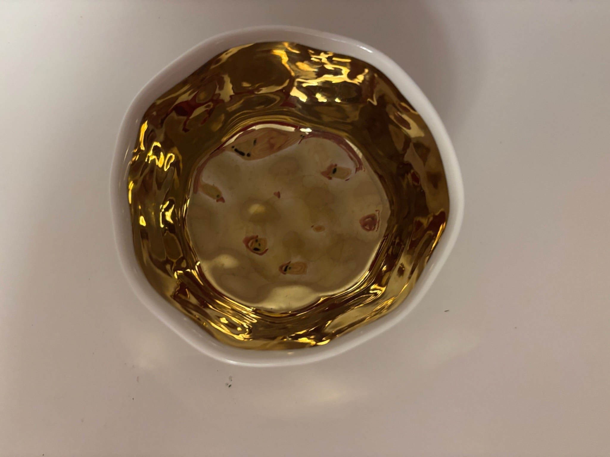 small ceramic bowl, metallic gold with white interior and rim