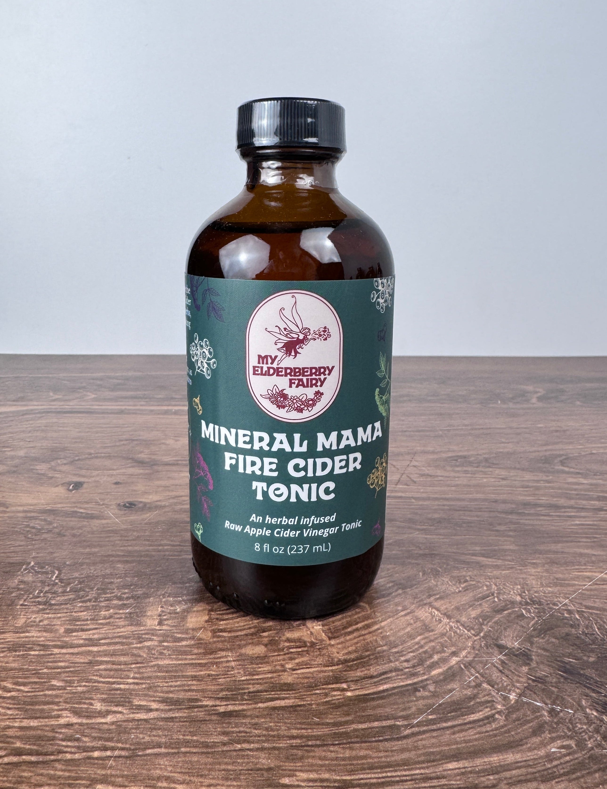 Bottle of 'Mineral Mama' Fire Cider Tonic on a wooden surface
